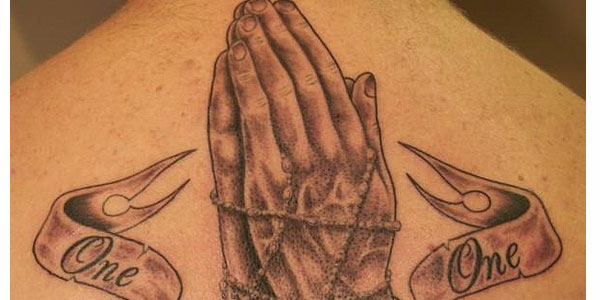 Praying hands, rosary beads & lettering tattoo