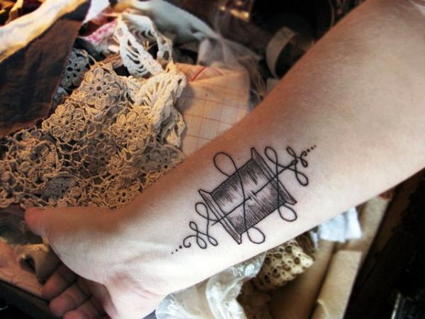 Needle And Thread Tattoo On Arm