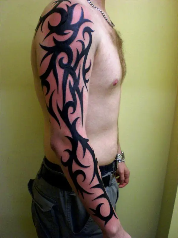 Awesome Tribal Chest And Sleeve Tattoo