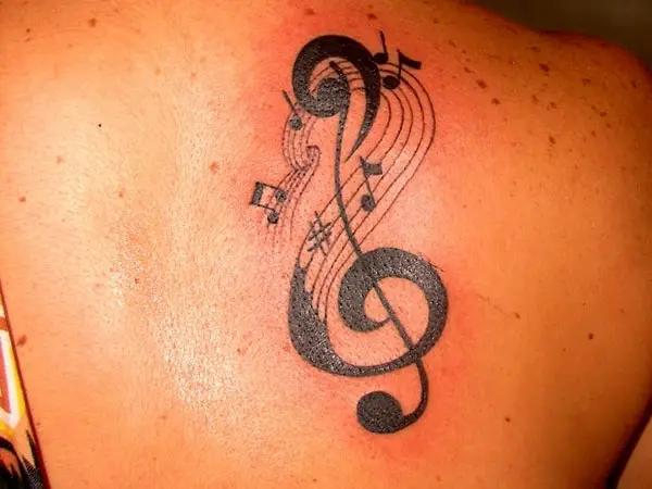 Small treble clef tattoo on the left inner ankle