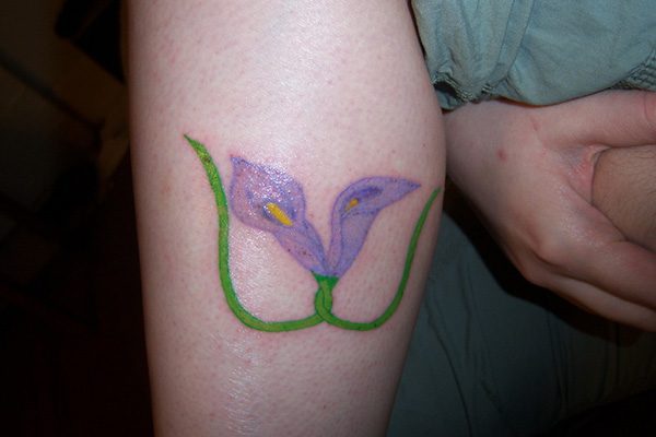 Black Ink Lily Flowers Tattoo On Girl Left Wrist