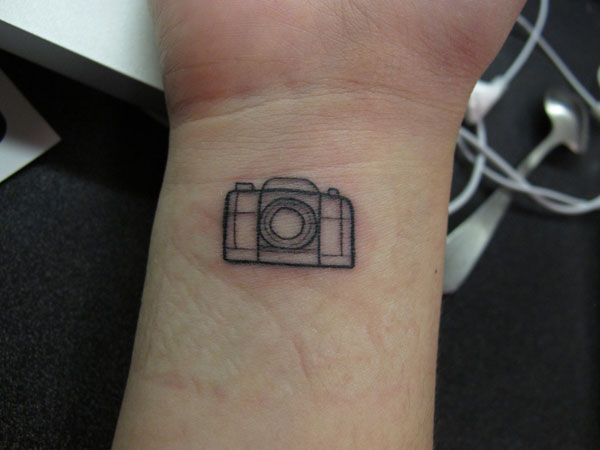 Tiny minimalistic camera tattooed on the finger