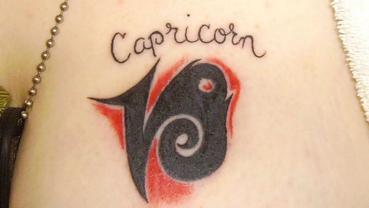 Girl Showing Her Capricorn Zodiac Symbol Tattoo On Nape