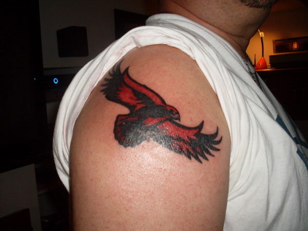 Traditional Black And Red Hawk With Flower Tattoo On Forearm