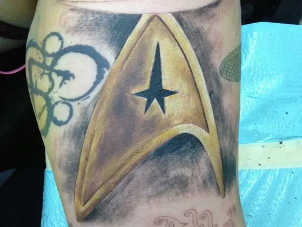 Big Tattoo of Yellow Colored Star Trek Insignia