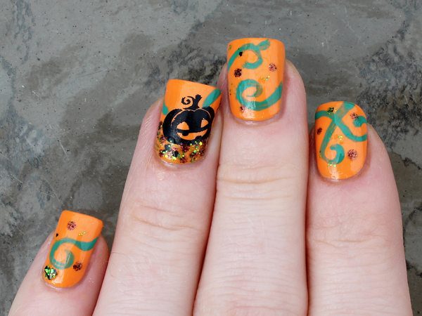 Orange Nails with Green Swirls, Glitter, and Single Black Pumpkin