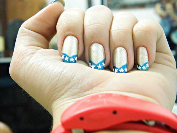 Wonder Woman Style Gold Nails with Blue Tips and White Stars