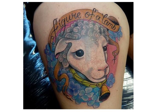 The Figure of a Lamb Colored Tattoo with Blue Flowers and Banner